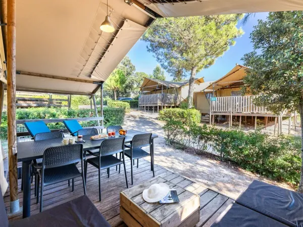 The Roan Lodgetent Premium has a spacious covered decking with lounge area and dining table.