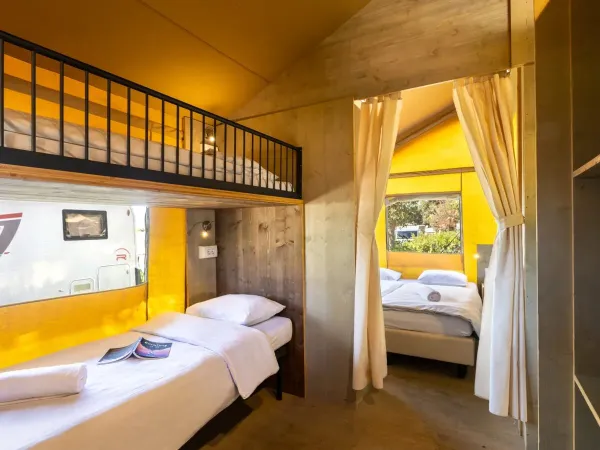 The Roan Lodgetent Premium bedroom with bunk beds equipped with pillows and single duvets.