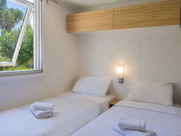 One bedroom with single beds in the Roan mobile home Supreme with 2 bathrooms.