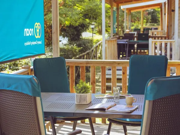 The Roan Premium Compact decking features a dining table with chairs.