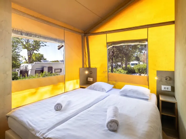 The Roan Lodgetent Premium bedroom with two single beds equipped with pillows and single duvets.