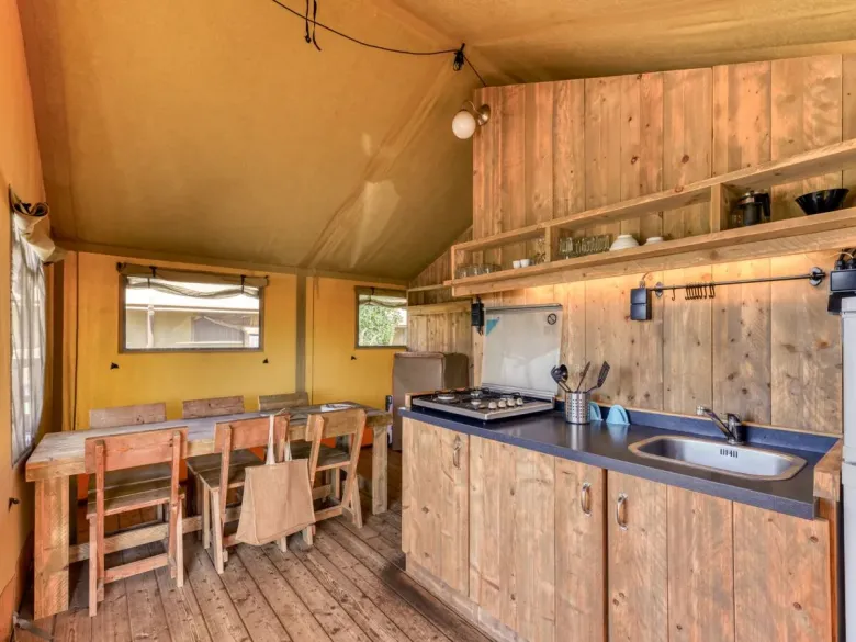 The Roan Lodgetent Luxe has a kitchen with a tall fridge and extensive kitchen inventory.