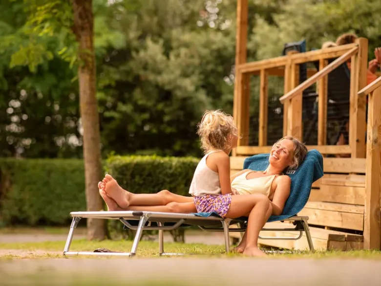 Mother and daughter on the luxurious lounger with canopy.