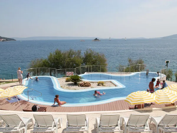 Swimming pool with sun beds and umbrellas at Roan camping Amadria Park Trogir.