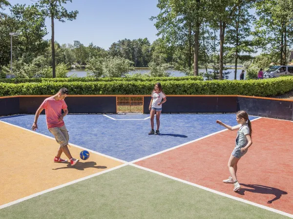 Playing soccer on the sports field at Roan camping De Schatberg.