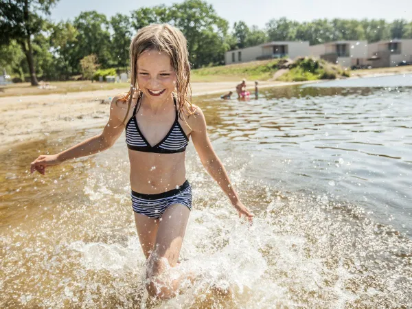 Girl walks through natural pool at Roan camping The Schatberg.