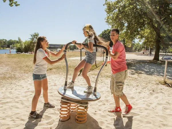 Children play in the playground at Roan camping De Schatberg.