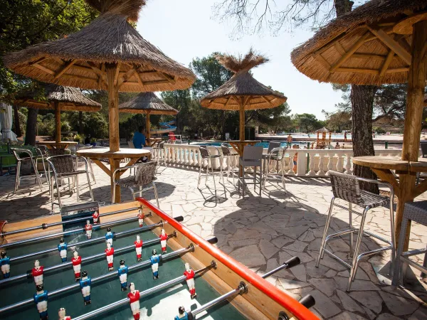 Terrace with foosball table at Roan camping La Pierre Verte.