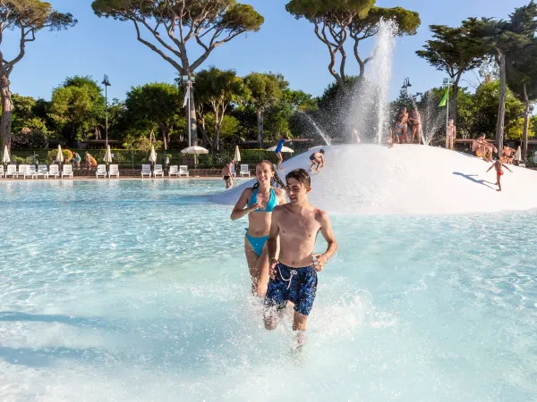 Children run through the lagoon pool at Roan camping Park Albatros.