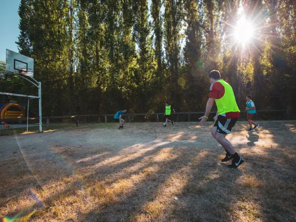 Playing soccer on the multi-sport field at Roan camping Château de Fonrives.