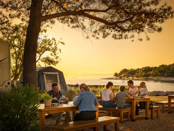 Picnic benches by the sea at Roan camping Valkanela.