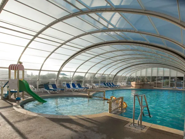 Indoor pool with slide at Roan camping Le Domaine de Beaulieu.