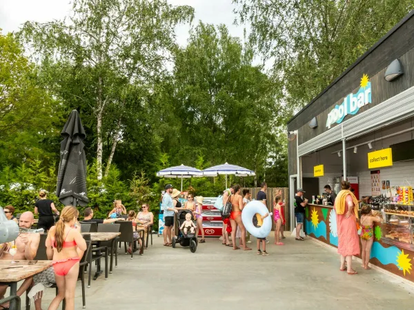 People pick up something tasty at the pool bar at Roan camping hu Birkelt village.