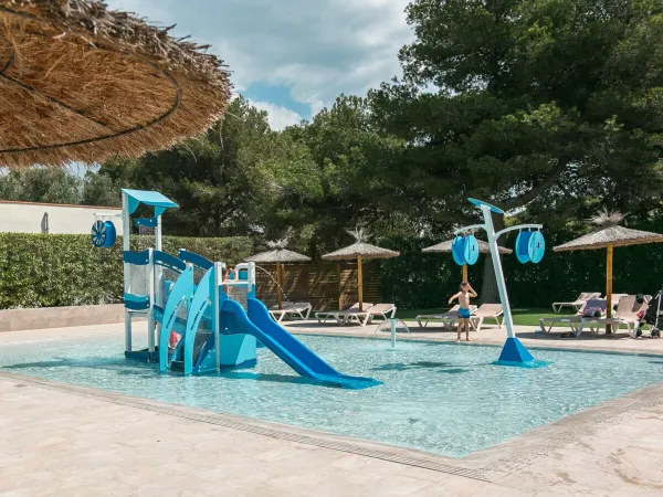 Toddler pool with playground equipment at Roan camping El Garrofer.