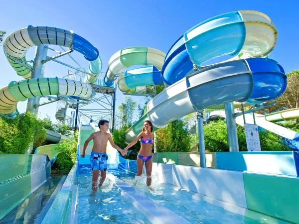 People have fun on the long slides at Roan camping Le Castellas.