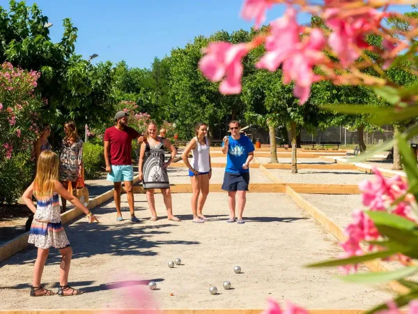 A family plays boules at Roan camping Le Castellas.