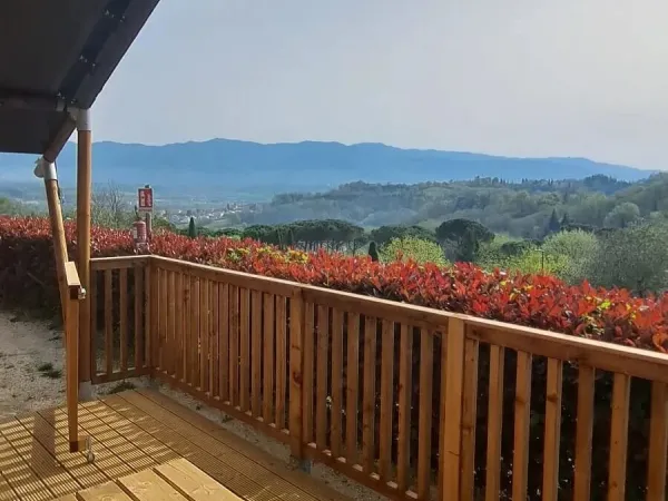 View of the Tuscan hills from the veranda of the Lodgetent Spring at Roan camping Norcenni Girasole.