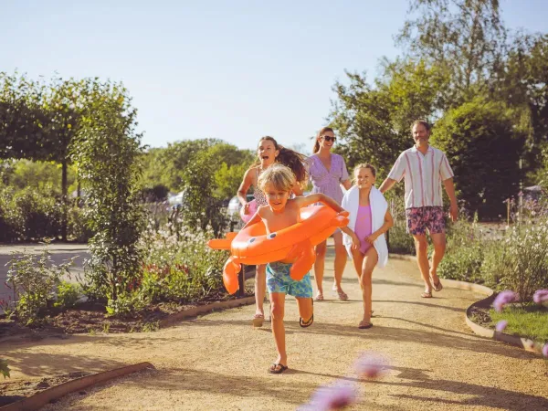 Family on their way to the pool at Roan campsite Le Domaine du Clarys.