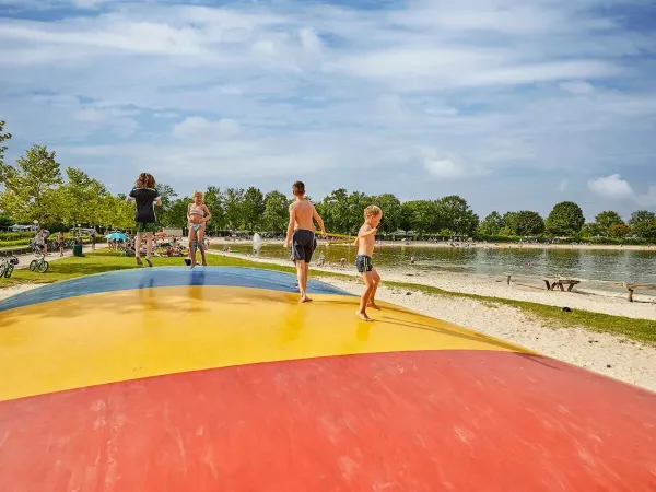 Airtrampoline with jumping children on the beach at Roan camping Terspegelt.