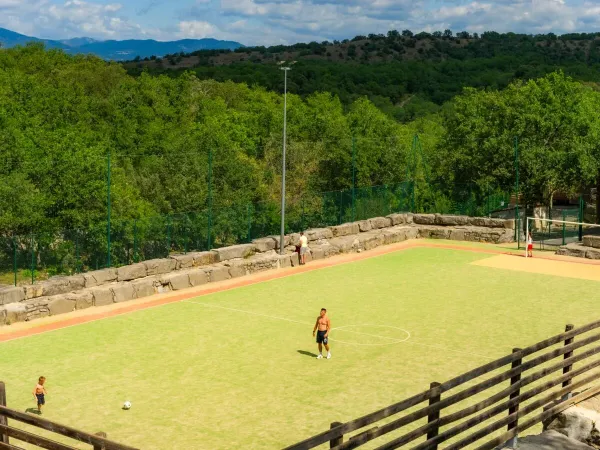 Playing soccer on the sports field at Roan camping Aluna Vacances.