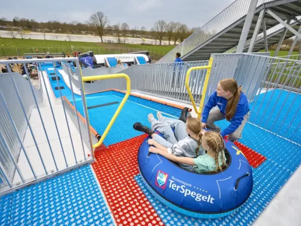 Children slide down the TubbytJump at Roan camping Terspegelt with a tyre.