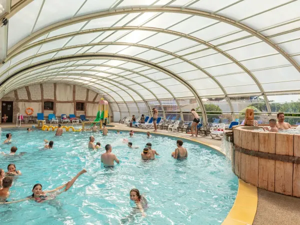 Indoor pool with slide at Roan camping Le Domaine de Beaulieu.