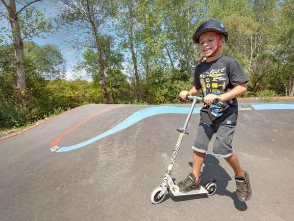 A young boy on the pumptrack at Roan camping Le Pommier.