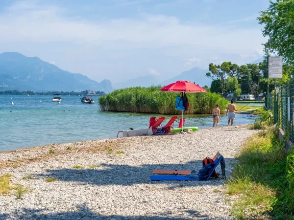 The pebble beach at Roan camping La Rocca Manerba.