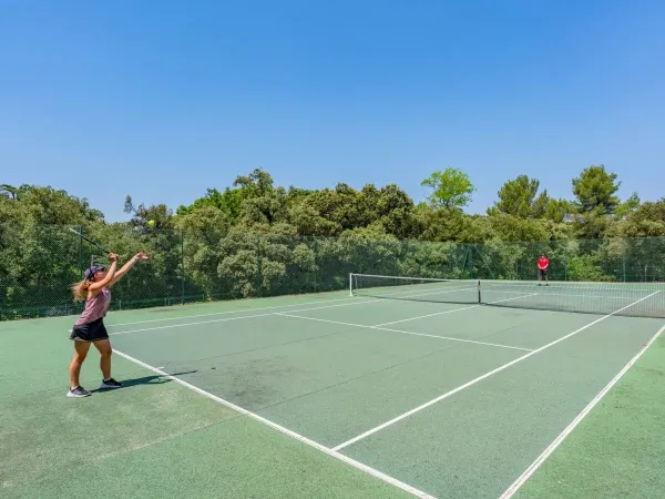 Guests play a game of tennis at Roan camping Domaine de Massereau.