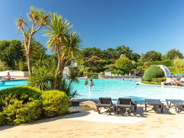 The swimming pool with loungers and beautiful garden at Roan campsite La Grande Métairie.