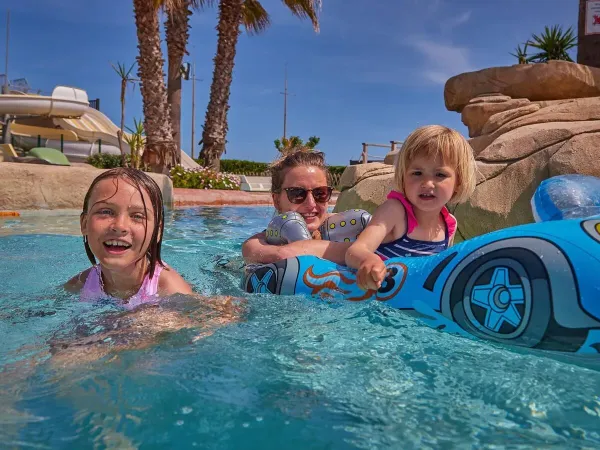 Family enjoy poolside fun at Roan camping Le Petit Mousse.