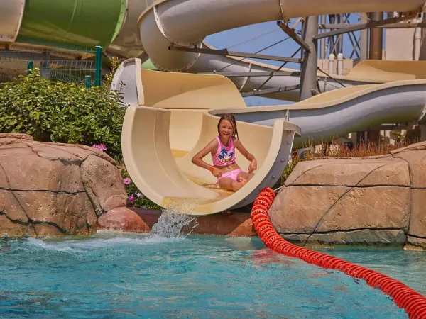 Girl slides down the slide at Roan campsite Le Petit Mousse.