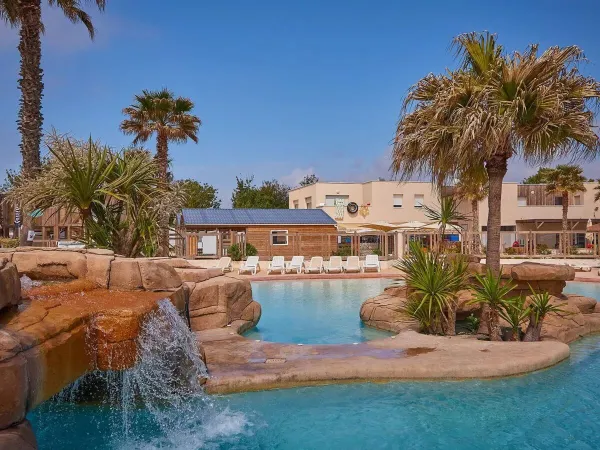 Beautiful planting by the swimming pool with waterfall at Roan campsite Le Petit Mousse.