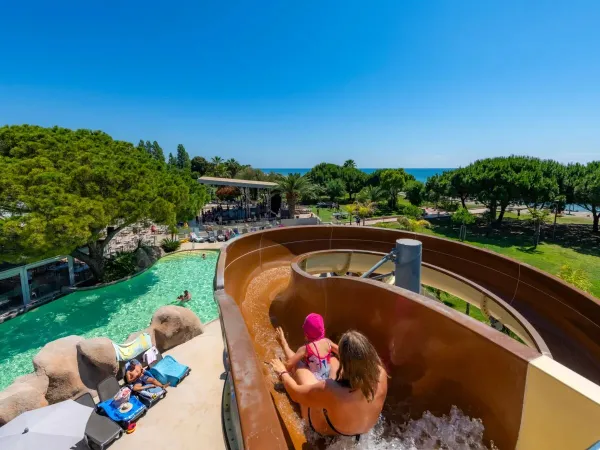 Mother and child slide down the slide at Roan campsite Arinella Bianca.