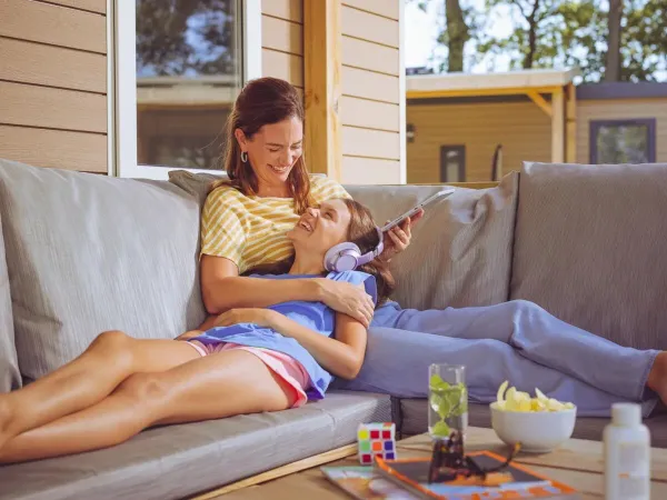 Mother and daughter enjoy a luxurious Roan accommodation on the lounge sofa.