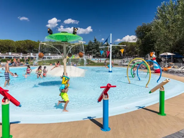 Children's pool with slides and sprayers at Roan campsite Marina Julia Camping Village.