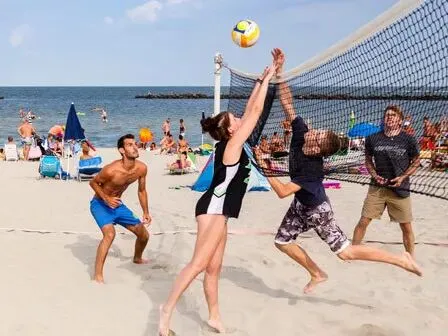 People playing beach volleyball on the beach located at the Vigna sul Mar campsite.