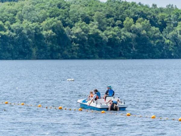 Family enjoy pedalos on the lake at Roan camping Le Lac des Vieilles Forges.