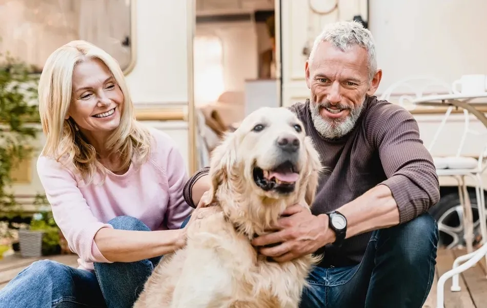 Guests greet their dog on the decking of a luxury Roan mobile home.